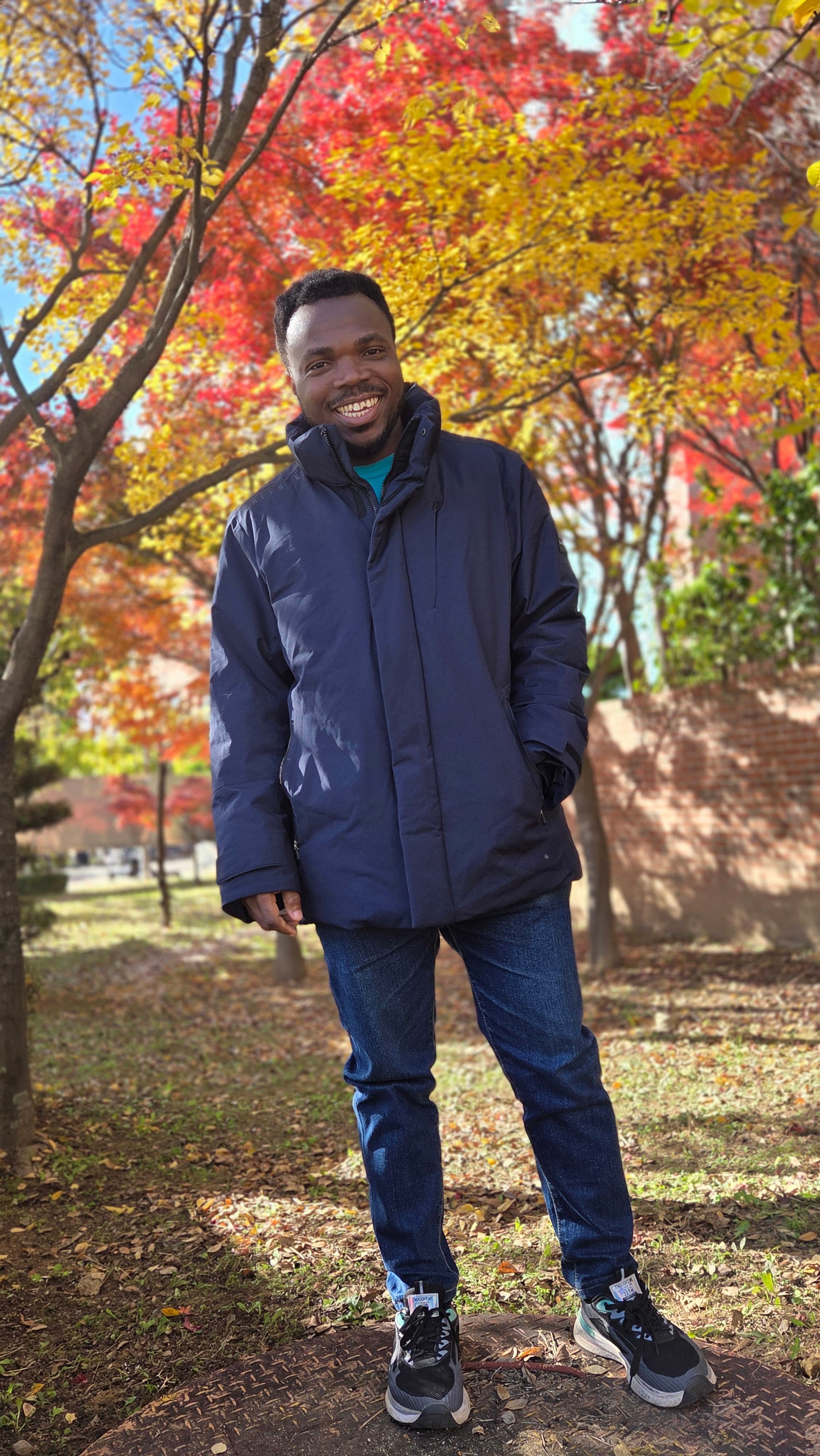 Anthony Uchenna Eneh outdoors in autumn leaves
